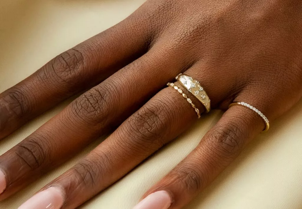 hand model wearing three dainty rings